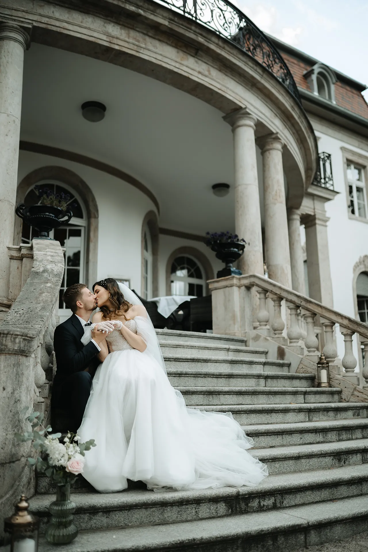 Hochzeitspaar auf der Treppe einer Villa
